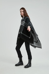Détail d'un poncho à carreaux noir et gris avec franges délicates et maille texturée