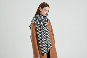 Détail de l'écharpe pied-de-poule noir et blanc avec glands élégants et texture douce