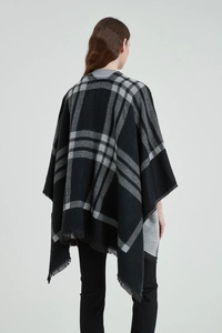 Détail de l'arrière d'un poncho classique à carreaux noir et blanc avec des franges