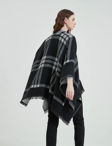 Détail d'un châle à carreaux noir et gris avec franges et texture douce aspect cachemire