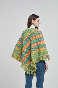 Detail of bohemian knit shawl featuring colorful zigzag jacquard patterns and soft fringe trim