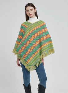 Detail of bohemian knit shawl with vibrant wavy patterns and fringed V-neckline