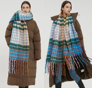 Close-up of rainbow plaid scarf showing thick knit texture and long tassel details
