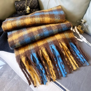 Dettaglio di sciarpa a quadri spessa con lunghe frange e morbida texture mohair