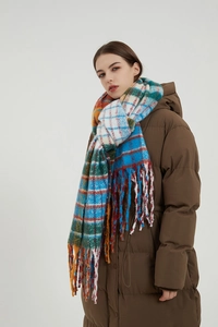 Detailed texture of thick rainbow plaid scarf with long tassels and winter puffer coat