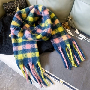 Dettaglio della sciarpa spessa in mohair a quadri rosa giallo blu con lunghe frange