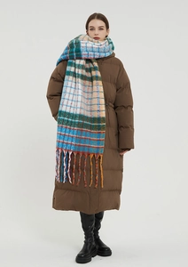 Detail of colorful rainbow checkered scarf with long tassels paired with brown down jacket
