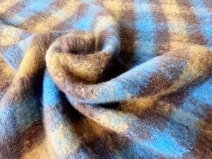 Dettaglio di sciarpa in finto mohair spesso con trame soffici a quadri blu e marroni