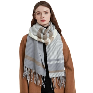 Women's autumn winter plaid scarf in grey and beige with tassels on brown coat
