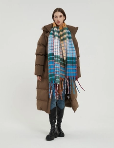 Detail of multi-color rainbow checkered scarf with thick tassels for winter fashion