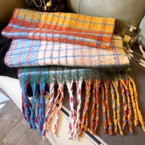 Close-up of thick rainbow plaid scarves with long tassels in various vibrant colors
