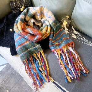 Detail of colorful rainbow plaid scarf with thick tassels on a luxury sofa setting
