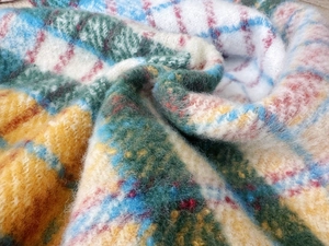 Detailed close-up of rainbow plaid scarf showing thick mohair texture and fringes