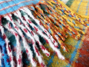 Close-up of thick rainbow plaid scarf featuring soft mohair texture and chunky tassels