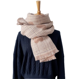 Plaid scarf with plush heart pattern and fringe tassels on a black knit sweater