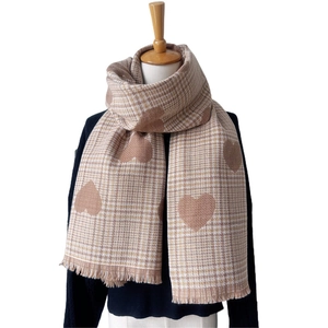 Detail of checkered heart scarf featuring soft camel texture and delicate fringe trim