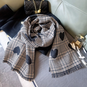 Winter plaid scarf with heart print and tassel fringe on a luxury background
