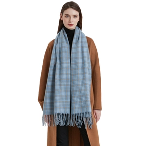 Blau-weiß karierter Schal mit langen Fransen über einem braunen Wintermantel