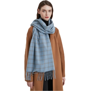 Klassischer blau-beiger Karoschal mit Fransen an einem camel-farbenen Wollmantel für den Winter