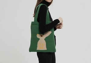 Dettaglio della borsa tote in maglia verde scuro con un simpatico motivo jacquard a coniglio