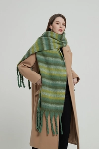 Detailed view of thick knit green and yellow striped scarf with long chunky tassels