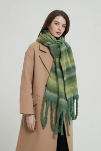 Detail of winter scarf featuring green and yellow stripes with thick chunky tassel fringe