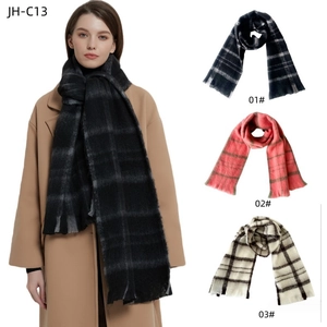 Detail showing soft bouclé yarn texture and fringe on black plaid scarfs for winter