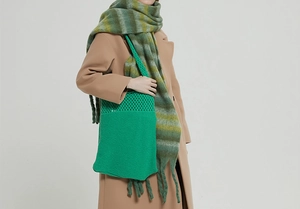 Borsa tote in maglia verde abbinata a un cappotto invernale per un look di tendenza