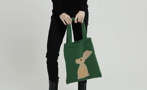 Dettaglio della borsa tote in maglia verde bosco con motivo a coniglio marrone