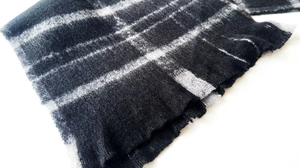 Close-up of black and grey plaid bouclé yarn fabric with warm brushed mohair texture