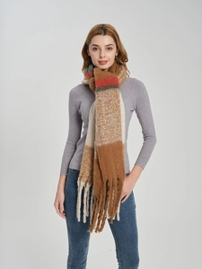 Close-up of thick plaid scarf texture with long fringe and warm knit material