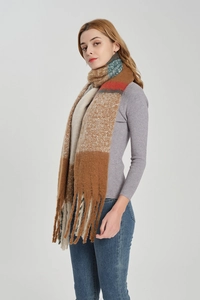 Detail of a large plaid scarf with earth tones, color-block patterns and long fringes