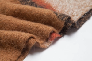 Close-up of thick winter scarf showing textured bouclé yarn and retro plaid pattern
