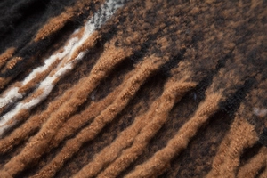 Detail of soft mohair knit scarf showing plaid pattern and handmade twisted fringe tassels