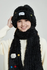 Detailansicht von schwarzem Winterset aus Kunstpelz mit bunten Knöpfen und Webeetikett