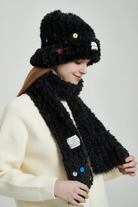 Detail von plüschigem schwarzem Winter-Set aus Hut und Schal mit bunten Knöpfen
