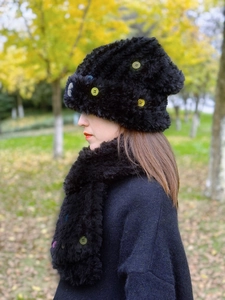 Detailansicht von schwarzem Winterset aus Mütze und Schal mit bunten dekorativen Knöpfen