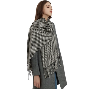 Κλασικό ασπρόμαυρο κασκόλ houndstooth με κρόσσια πάνω από γκρι παλτό ψαροκόκκαλο