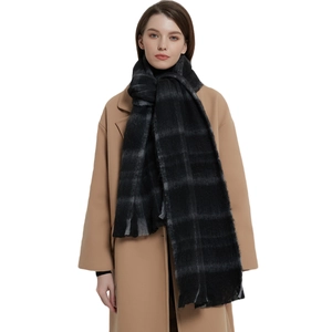 Classic black and grey checkered scarf with fringe worn over a beige wool coat