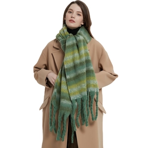 Thick colorful striped scarf with chunky fringe worn on a beige wool coat