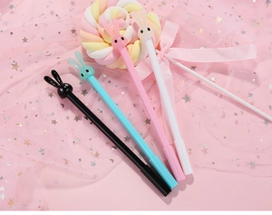 Close-up of cute long-eared bunny gel pens in four colors on a dreamlike pink background