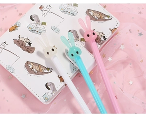 Close-up of cute cartoon long-eared bunny pens in pink, blue, and white colors