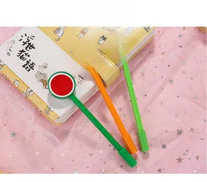 Nahaufnahme süßer Obst-Lollipop-Stifte mit Wassermelonen- und Orangendesign auf Notizblock