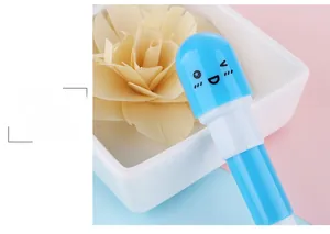 Détail macro du stylo capsule bleu ciel avec un joli design emoji sur fond bicolore