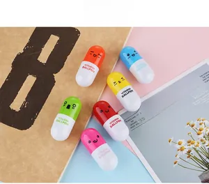Mini stylos à bille en forme de capsule, six couleurs, visages mignons sur décor de papeterie
