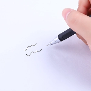 Matte black gel pen with silver metal tip and rubber grip writing on white paper