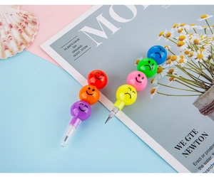Close-up of colorful stackable emoji pencils with smiley face segments on magazine background