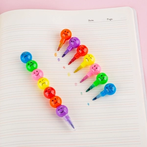 Stackable rainbow crayons with colorful smiley face units on a notebook for children's art