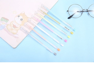 Close-up of 8 colored gel pens for journaling with cute notebook and glasses