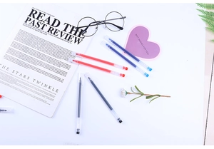 Detailed set of black, blue, and red gel pen refills on a minimalist workspace